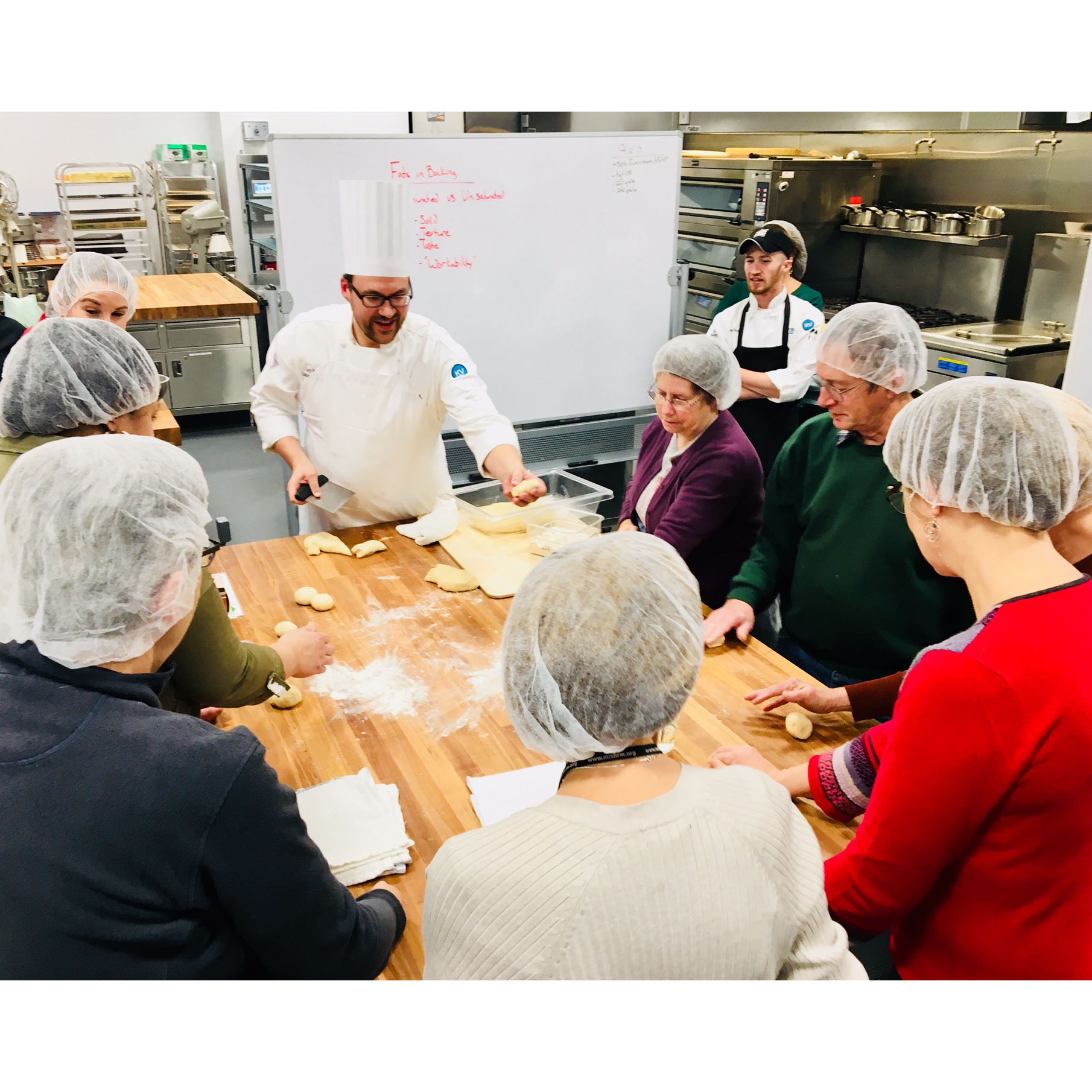 A culinary instructor leads a class in a learning kitchen.