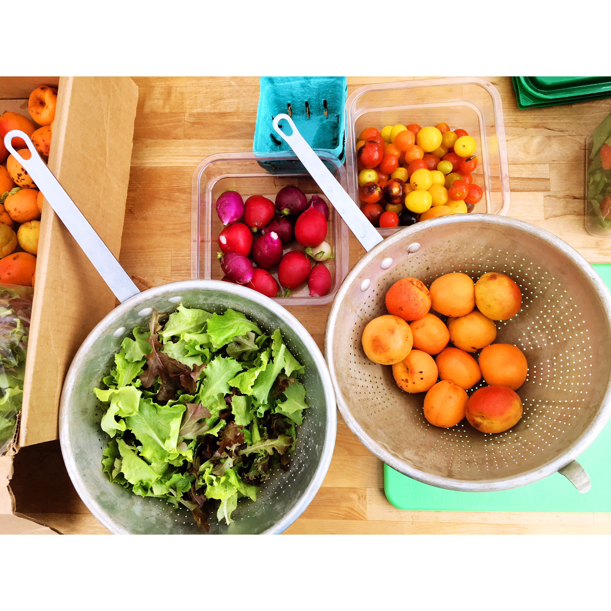 Colorful fruits and vegetables in containers on a countertop.